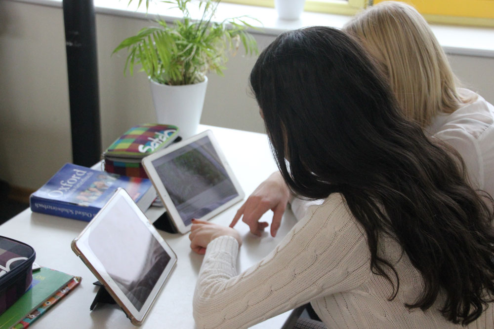Zwei Schülerinnen lernen im Unterricht mit Tablets